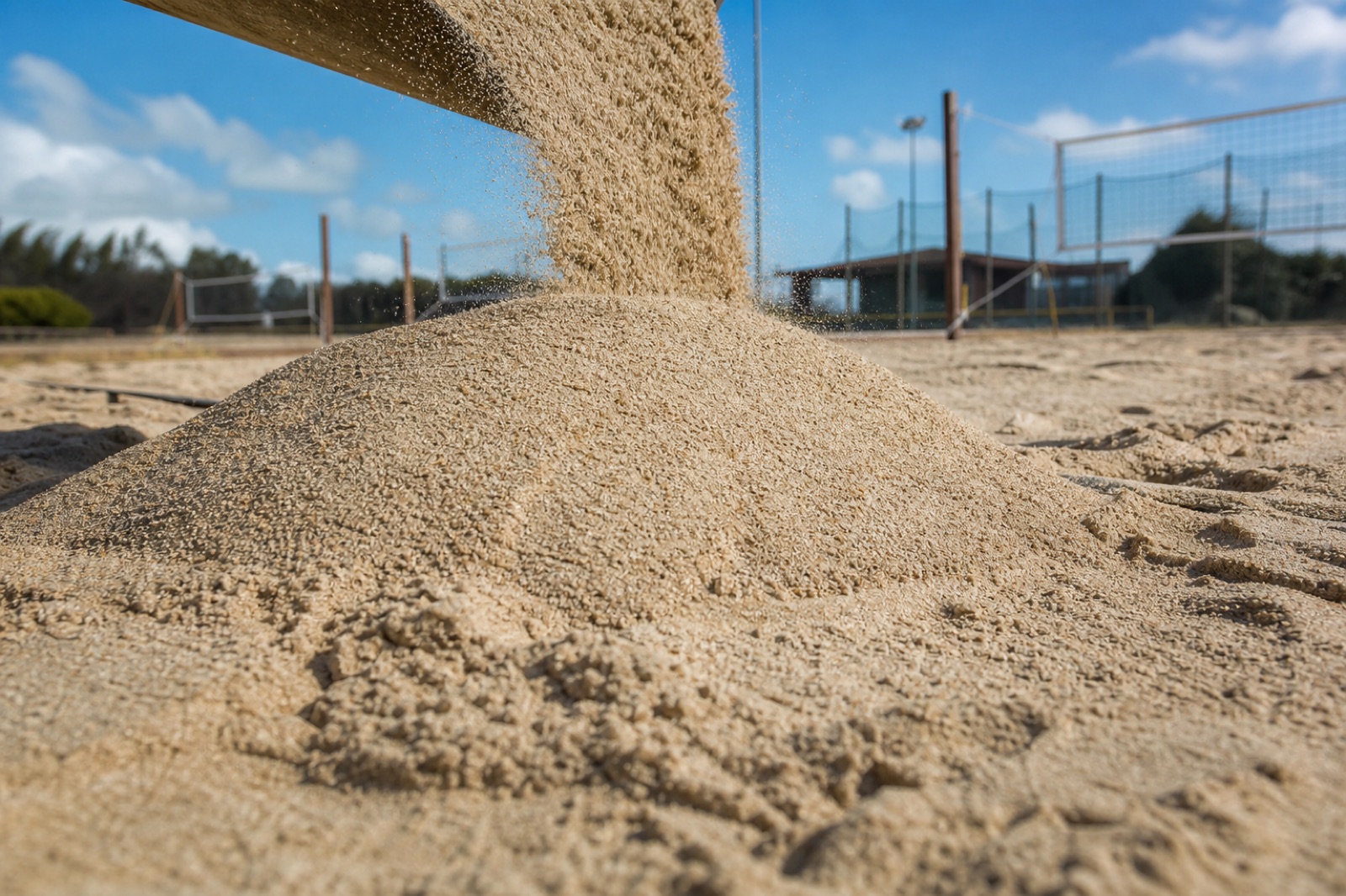 Areia sendo despejada em quadra de beach tennis, mostrando textura e profundidade.